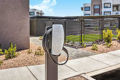 Modern apartment complex featuring electric vehicle charging station with elegant landscaping, showcasing eco-friendly living and convenient amenities at Summit on Boulder Apartments.