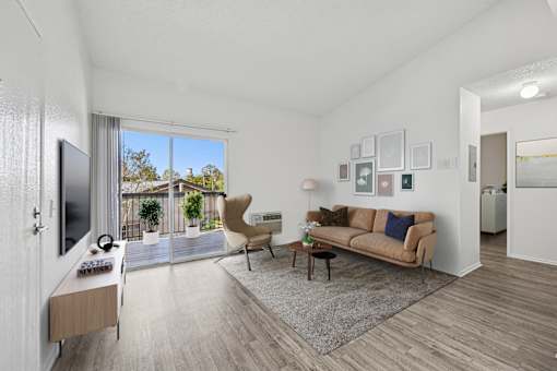 Bright living room with wood-style floors at Sunnyside Senior Apartments in San Dimas, CA