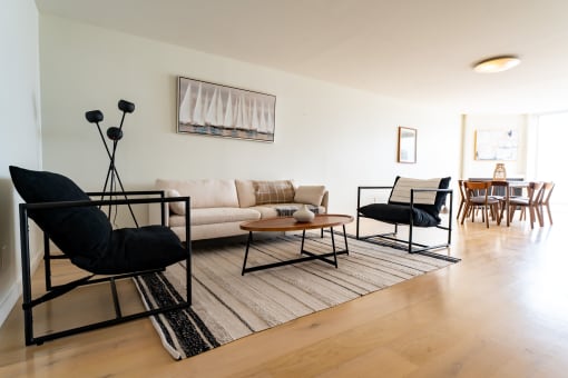 Apartments in Santa Monica for Rent - San Vicente Tower - Open Living Room with Hardwood Flooring, Stylish Decor, Dining Area, and Large Window