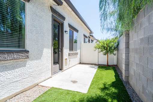 A modern house with a white exterior and a small garden area.