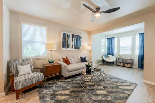 Bright and spacious living room with ceiling fan, stylish vinyl plank flooring, and open-concept layout at The Sanctuary at 331 in Santa Rosa Beach, FL