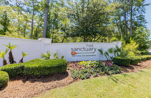The Sanctuary sign is displayed on a wall with a garden in front.