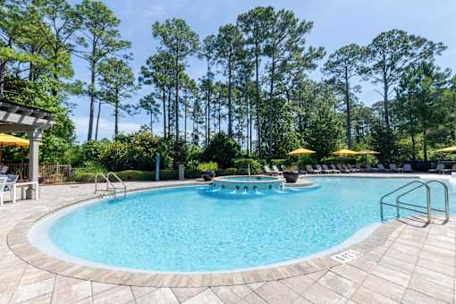 Outdoor swimming pool surrounded by lush landscaping and comfortable seating at The Sanctuary at 331 in Santa Rosa Beach, FL