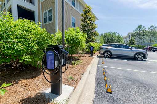 A parking lot with a car and a charging station.
