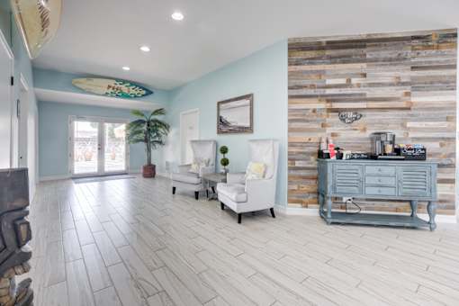 A living room with a white couch and a wooden wall.