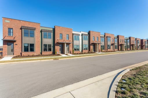 Apartments for Rent in Gallatin, TN - The Gardens at Preston Park - Street View of Brick Property Exterior, with Large Windows and Plant Beds.