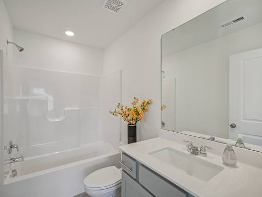 Modern bathroom with granite vanity and storage at The Maple Raleigh townhomes