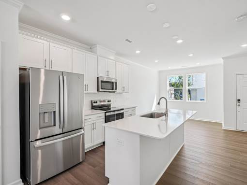 Spacious kitchen with wood-style flooring in The Maple Raleigh townhomes