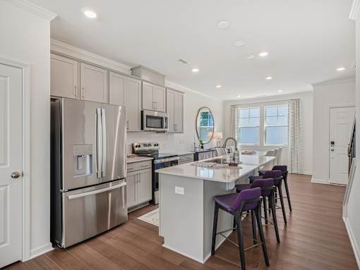 Bright dining area and kitchen with stainless steel appliances at The Maple Raleigh townhomes