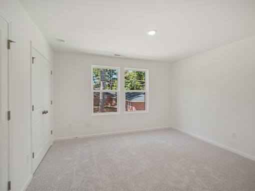 Large bedroom with windows and plush carpeting in The Maple 3-bedroom townhomes Raleigh NC