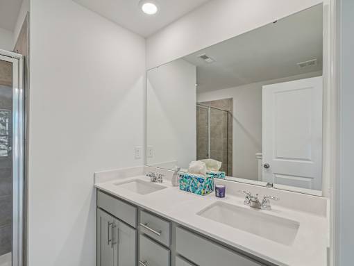 Modern bathroom with granite vanity and storage at The Maple Raleigh townhomes