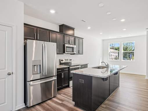 Modern kitchen with stainless steel appliances at The Maple townhomes Raleigh NC