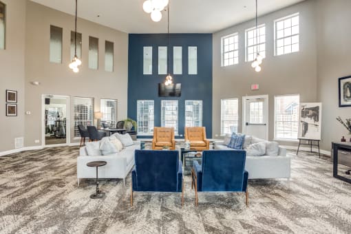 Apartments near Glendale Heights - large clubroom resident lounge with blue chairs and a couch and a table