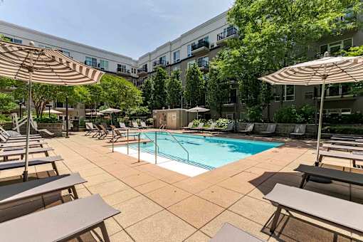A large outdoor pool area with sun loungers and umbrellas.