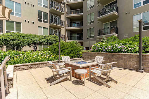 A patio with chairs and a table in front of a building.