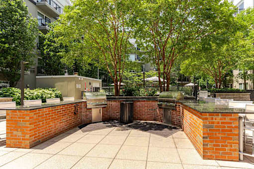 A courtyard with a brick wall and a fountain in the middle.