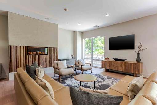 A living room with a brown couch and a flat screen TV mounted on the wall.