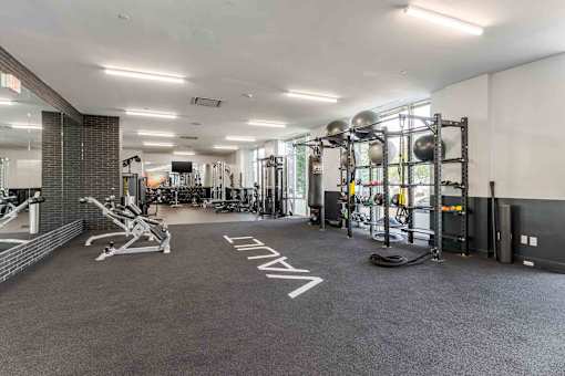 A gym with a variety of equipment including weights and cardio machines.
