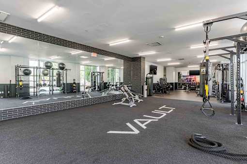 A gym with a variety of equipment and a large mirror on the wall.