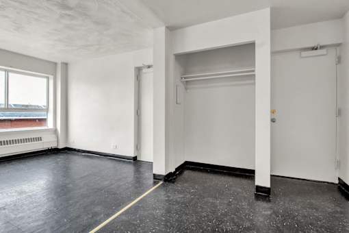 Empty room with white walls and black floor.