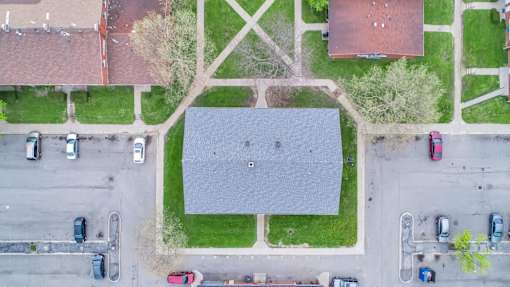 A parking lot with cars and a building in the background.