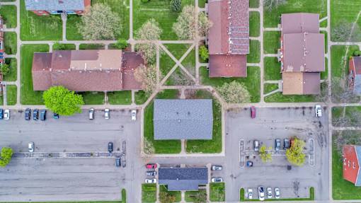 A parking lot with cars and a building in the background.