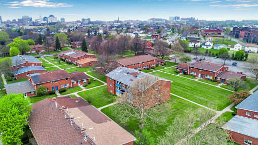 A view of a campus with buildings and a city in the background.