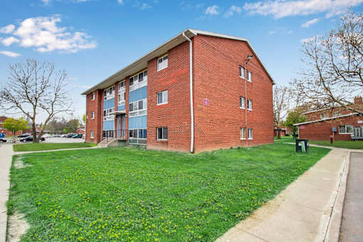 A red brick building with a green lawn in front.