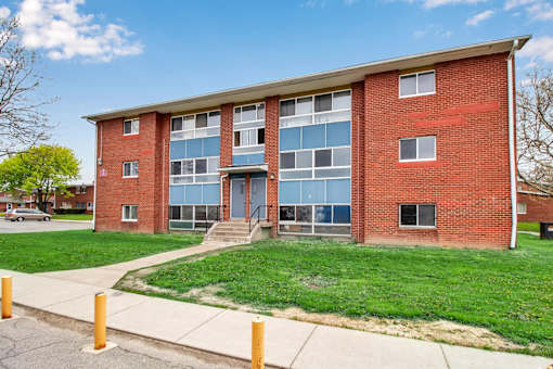 A red brick building with a green lawn in front.