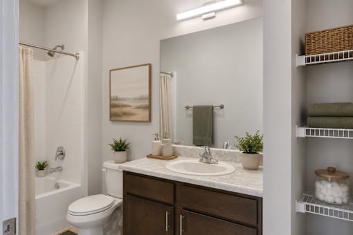 Professionally staged bathroom with oversized vanity and linen storage at Townes at Clarkston Centre in Clarkston, GA.
