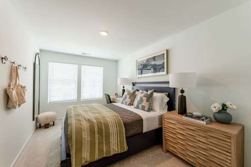 Spacious secondary bedroom with carpet flooring, large windows, neutral finishes, and modern decor at Townes at Olde Birch in Raleigh, NC.