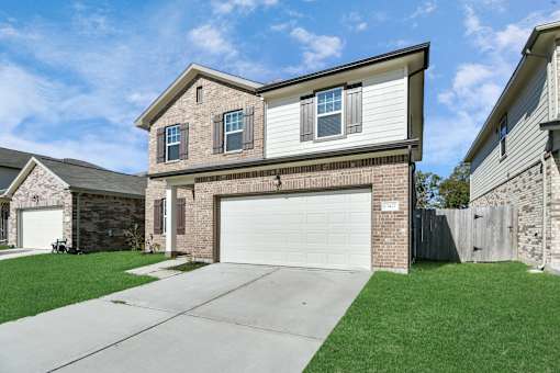 A two-story house with a garage is located in a residential area.