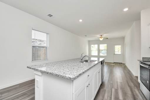 A kitchen with a granite countertop and white cabinets.