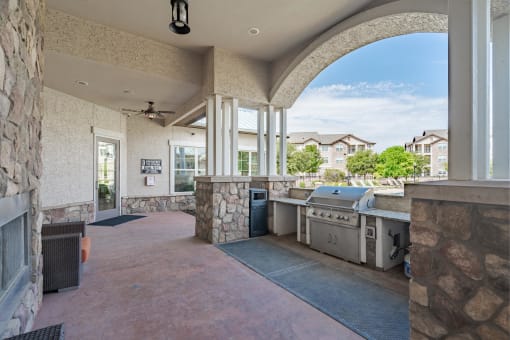 an outdoor kitchen with a grill and a large window
