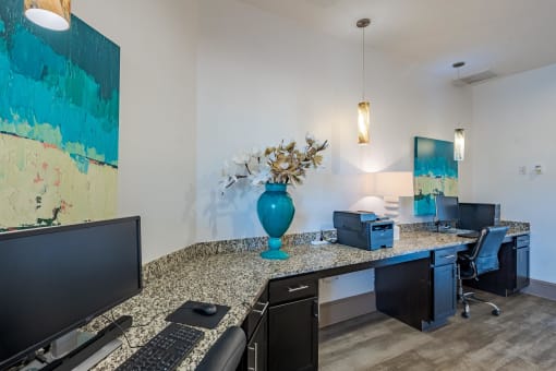 an office area with a counter and a television and a vase with flowers