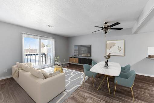 A living room with a white couch, a white coffee table, and a ceiling fan.