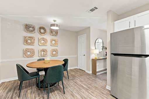 A kitchen with a table and chairs and a refrigerator.