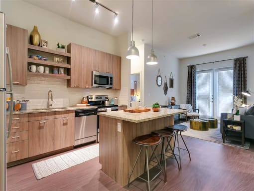 Rowlett TX Apartments for Rent - Village of Rowlett - Spacious Kitchen with Wood-Style Cabinetry, Wood-Style Flooring, and a Kitchen Island