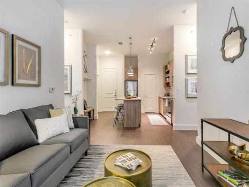Rowlett TX Apartments - Village of Rowlett - Living Room with View of the Kitchen and Wood-Style Flooring