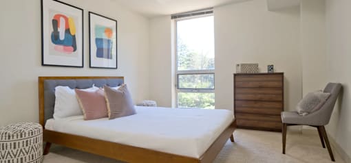 A bedroom with a large bed and a chair.