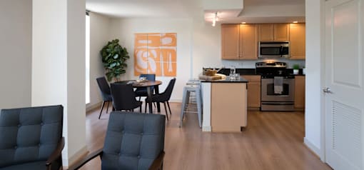 A kitchen with a dining table and chairs.