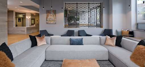 A grey couch with blue and brown pillows in a room.