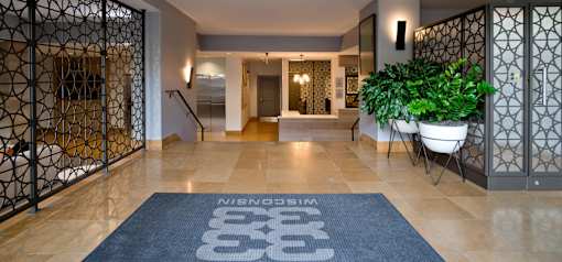 A hallway with a blue rug on the floor that says "Nestlé" on it.