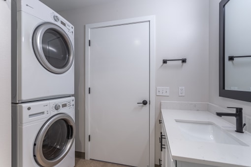 a laundry room with a washer and dryer and a sink
