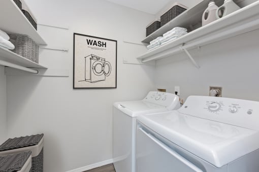 Hinton Height_Cottage Grove_MN_a washer and dryer in a white laundry room with a sign that says