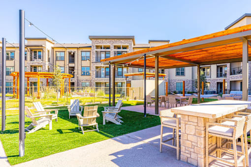 A patio with a table and chairs is in front of a building.