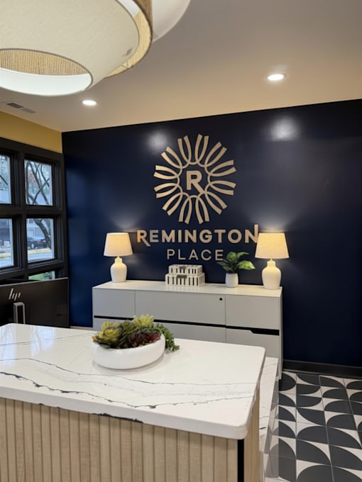 A reception area with a counter and a sign that says Remington Place.