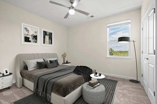 Bright spacious bedroom at Hawks Landing Apartments in Hickory, NC with modern furnishings and ceiling fan