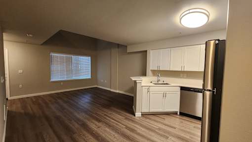 A kitchen with white cabinets and a black refrigerator.