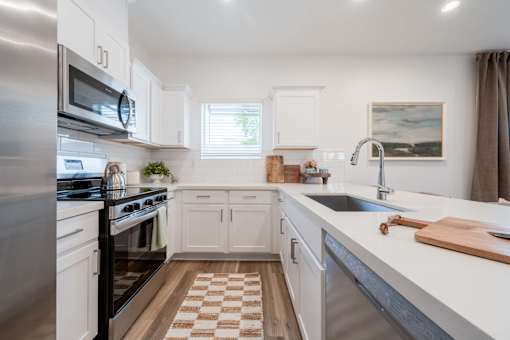 A kitchen with white cabinets and a checkered floor.